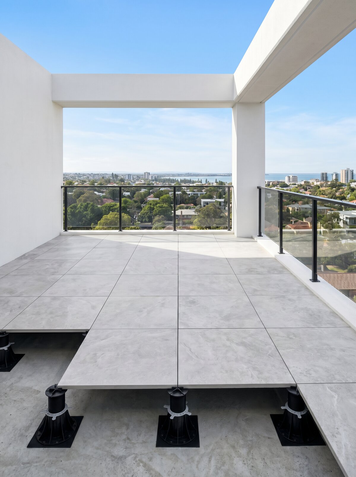 Moderner Balkon mit Stelzlager-Terrasse aus hellgrauen Platten