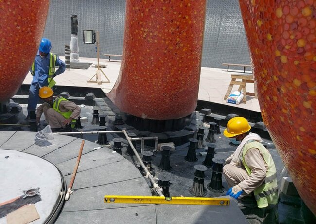 Nivellierung der Ausgleichslatte durch einen Mitarbeiter während der Montage