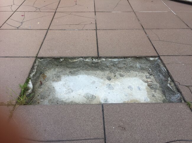 Abgefallene Fliesen von der verklebten Terrasse