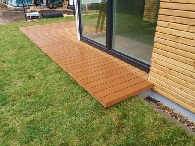 Komposit-Terrasse auf dem Boden auf Stelzlagern, im Garten auf dem Rasen