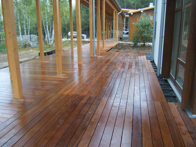 Große Terrasse aus Naturholz auf dem Boden auf Balken und höhenverstellbaren Stelzlagern solver