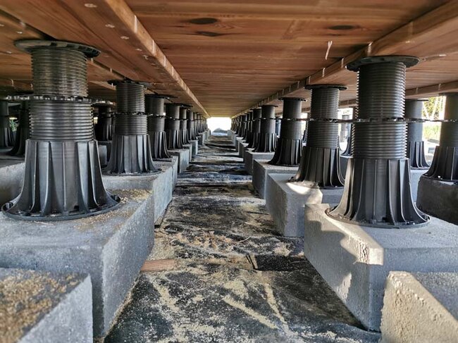 Unterbau der Stelzlager Terrasse mit Dielen und Balken auf höhenverstellbaren Stelzlagern