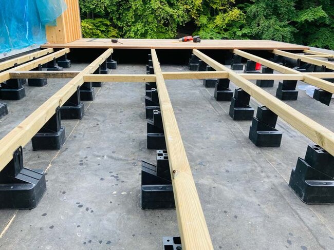 Adjustable pedestals on terrace pavers with evenly spaced terrace joists