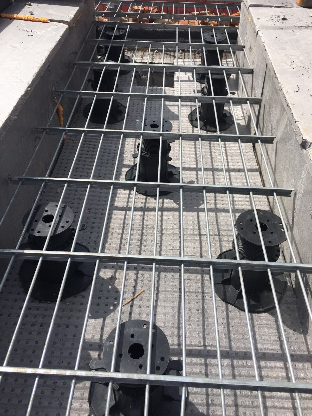 Stelzlager unter Gittern auf der Terrasse oder dem begrünten Dach