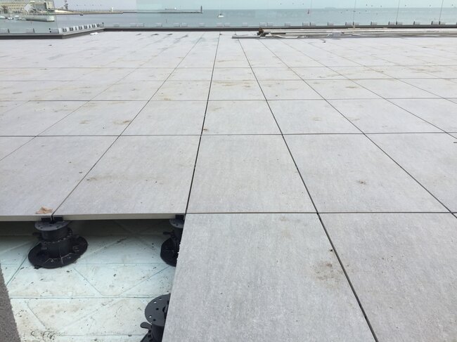Stelzlager Terrasse in einer Küstenstadt aus Terrassenplatten auf höhenverstellbaren Stelzlagern verlegt