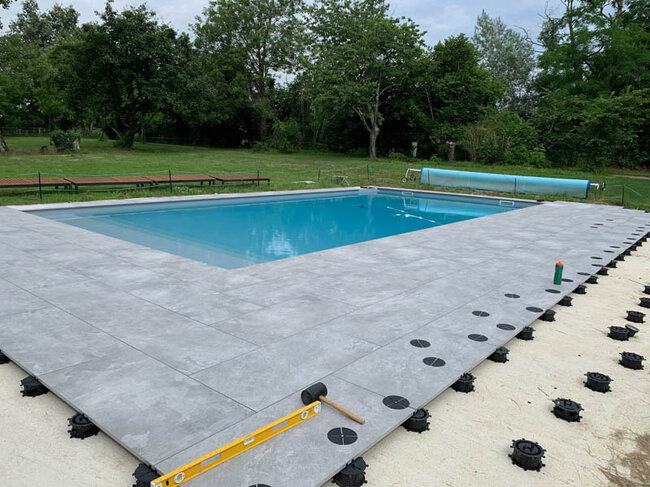 Moderne Bodenbrunnen auf einem Platz aus dunklen Betonplatten