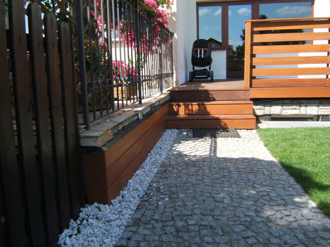 Kleiner Holzterrasse mit Markise und Holz-Gartenzaun
