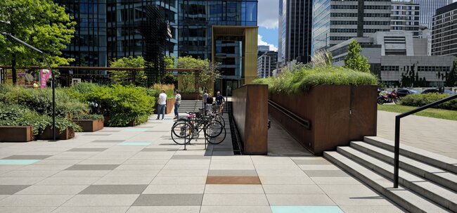Großformatige Terrassenplatten auf einem öffentlichen Platz vor einem modernen Bürogebäude.
