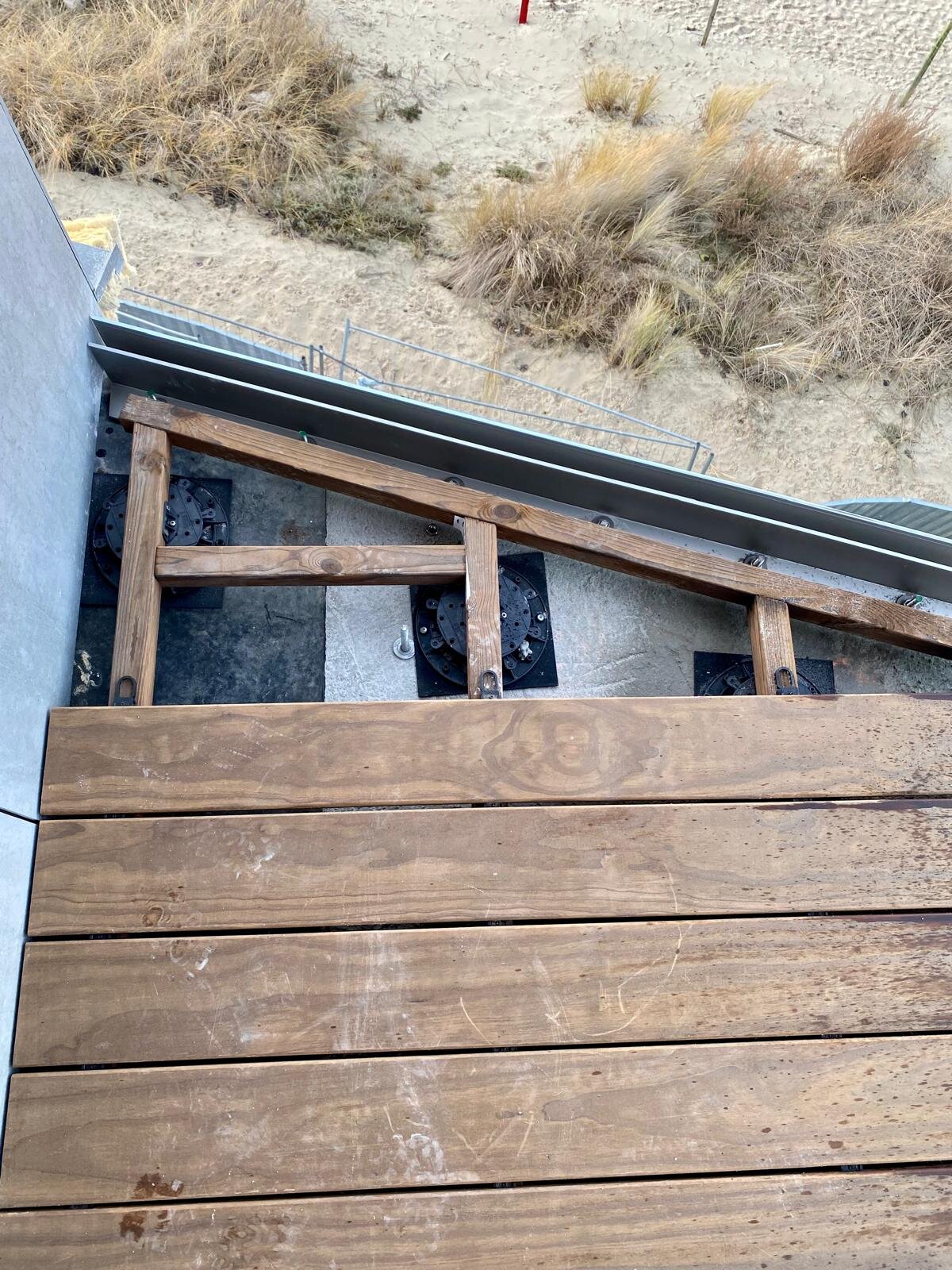 Montage einer Holzterrasse auf höhenverstellbaren Stelzlagern mit Blick auf die Dünen
