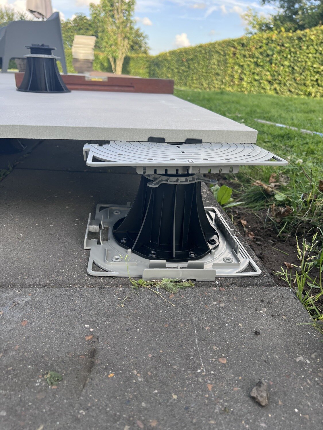 Kanten-Stelzlager höhenverstellbar mit Druckplatte unter heller Terrassenplatte
