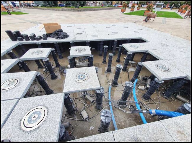 Granitplatten mit Düsen auf hohen verstellbaren Stelzlagern der Stelzlager Terrasse verlegt.