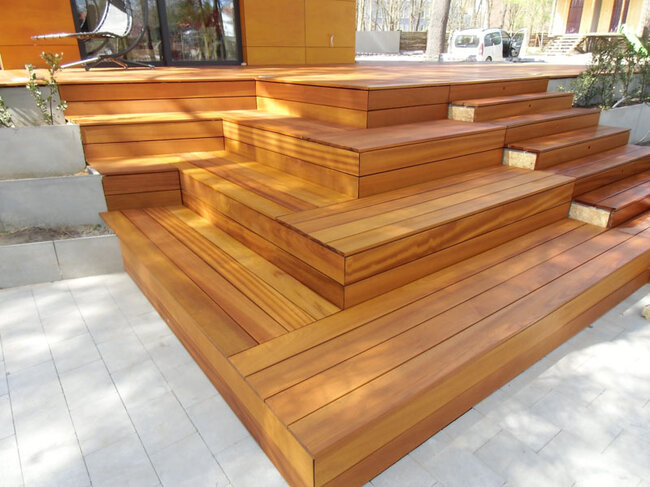 Modernes Holzterrassen-Deck mit Kaskadentreppen und Betonpflanzgefäßen