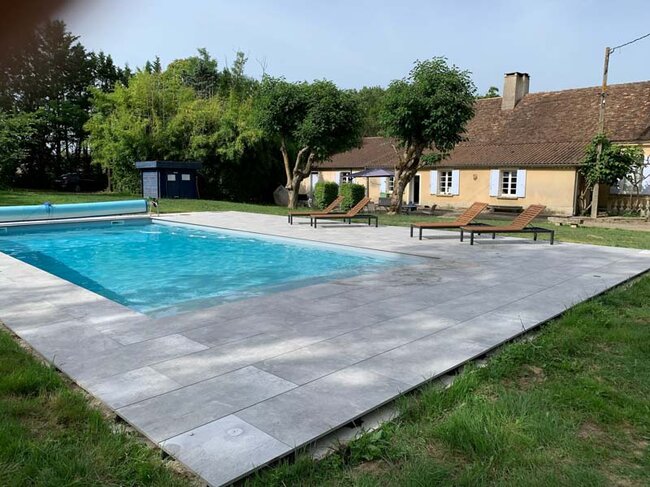 Moderne Terrasse mit grauen Feinsteinzeugplatten am Gartenpool