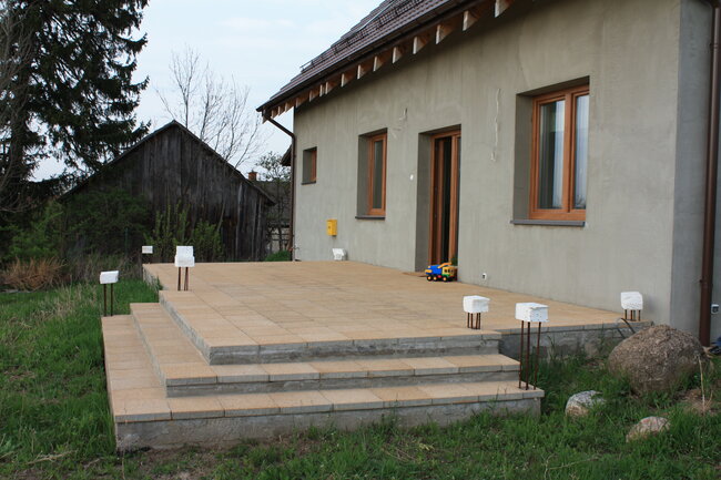 Terrasse aus hellen Betonplatten mit Treppen während der Fertigstellung