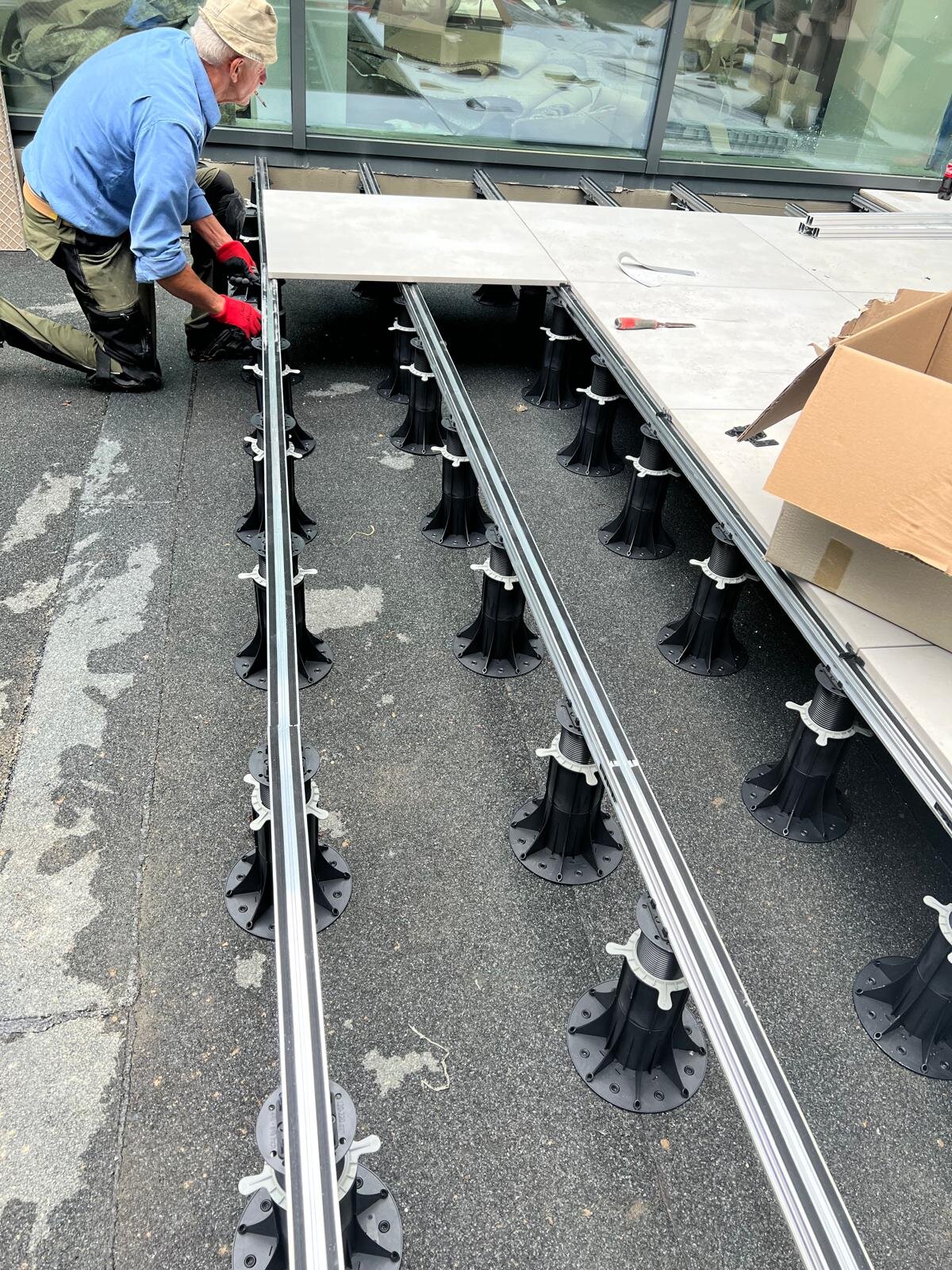 Montage von Terrassenplatten auf Aluminiumprofilen und höhenverstellbaren Stelzlagern