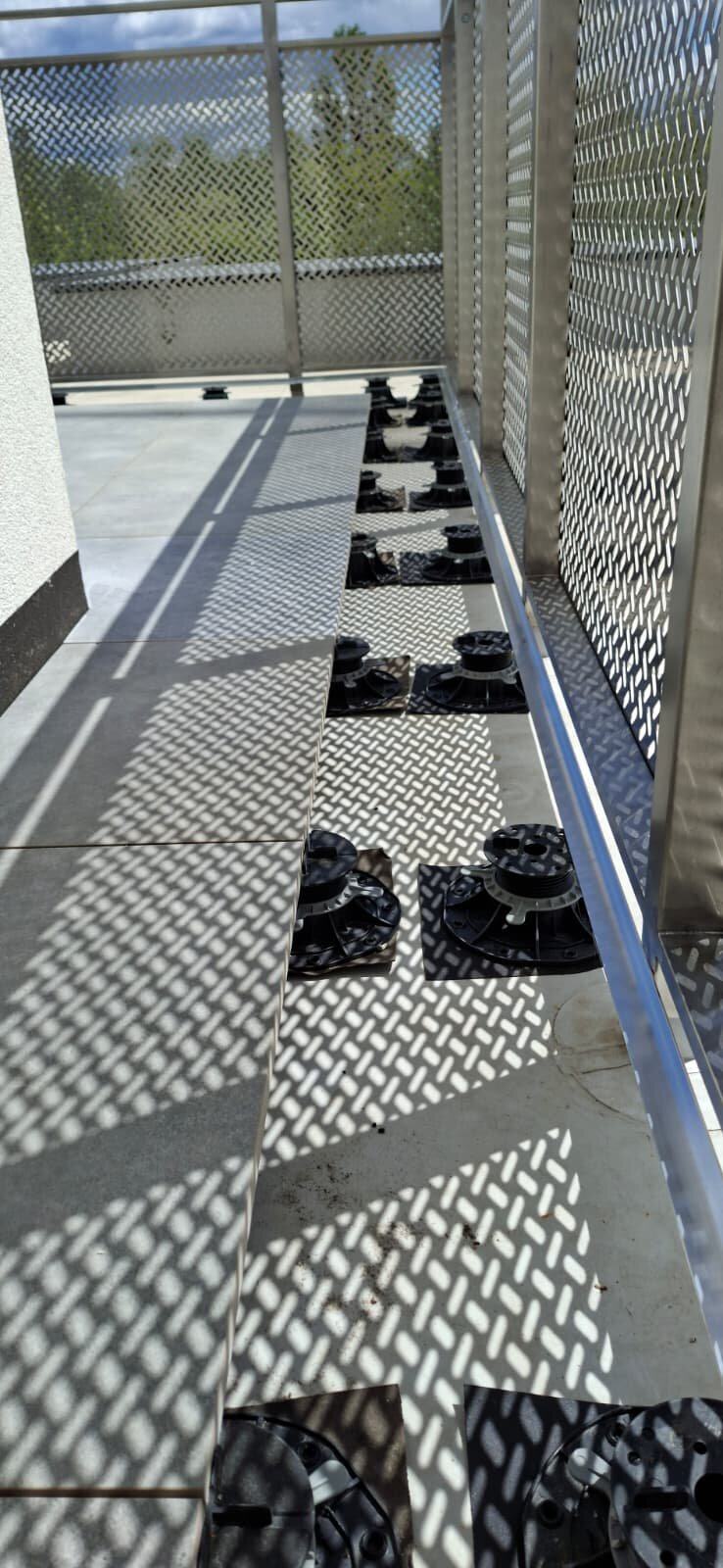 Verstellbare Stelzlager unter Terrassenplatten am Geländer