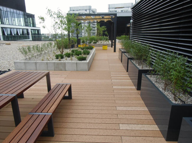 Moderne Stelzlager Terrasse aus WPC-Dielen mit Pflanzkübeln und Möbeln