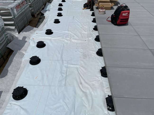 Vorbereitung des Untergrunds und der höhenverstellbaren Stelzlager für die Montage der Terrassenplatten