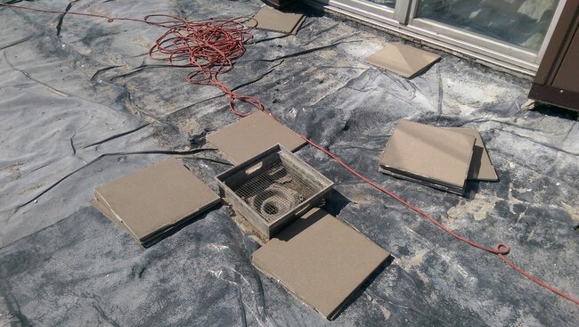 Langer Dachterrasse mit Geländer und Platten in einem Wohnblock