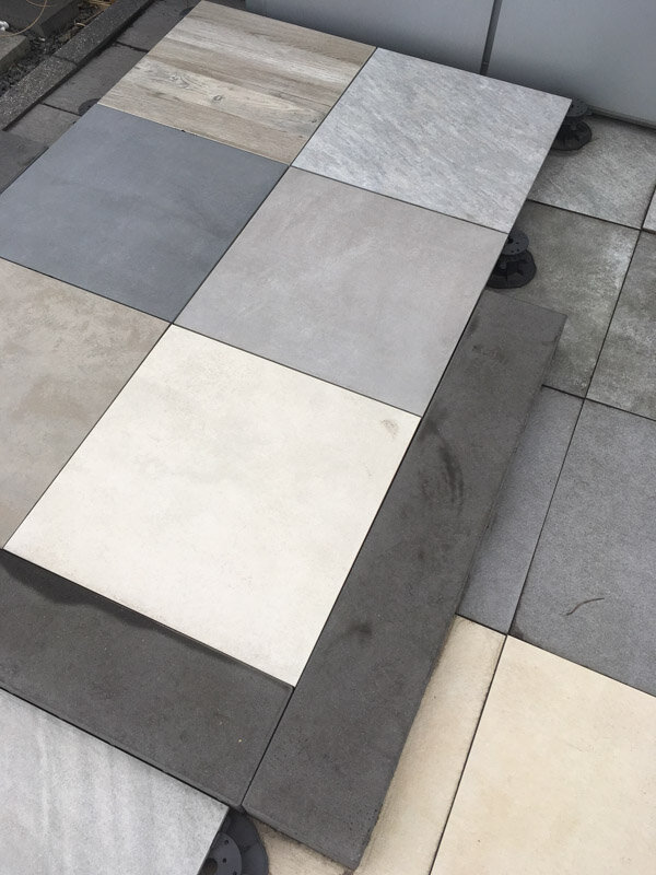 Verschiedene Feinsteinzeug-Terrassenplatten verlegt auf höhenverstellbaren Stelzlagern