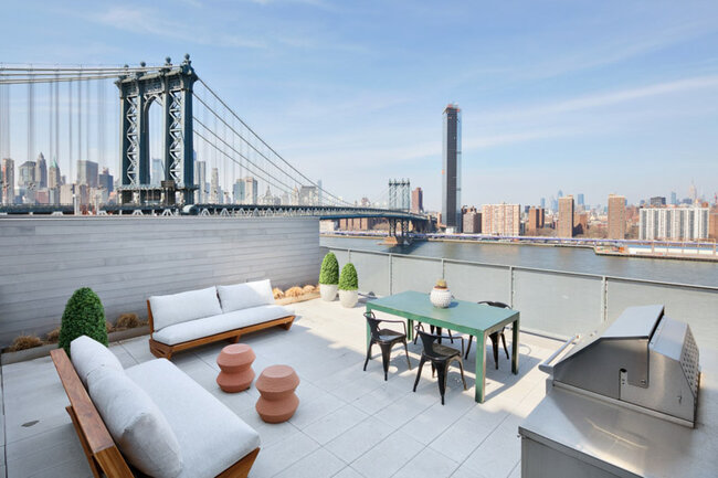 Luxuriöse Dachterrasse mit Möbeln und Blick auf die Manhattan Bridge