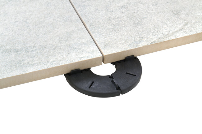 Foto, das die Umsetzung eines Terrassenprojekts mit Betonplatten unter Verwendung von Stelzlagern fester Höhe zeigt.
