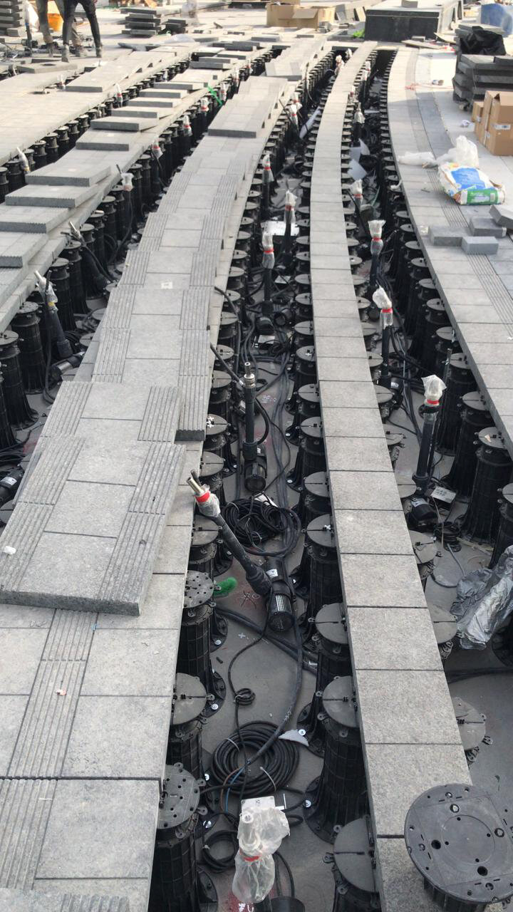 Foto einer Stelzlager Terrasse mit Keramikplatten während der Montage auf höhenverstellbaren Stelzlagern STANDARD.