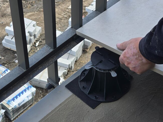 Ausgerichteter höhenverstellbarer Stelzlager Standard auf der Baustelle auf dem Balkon mit Platte