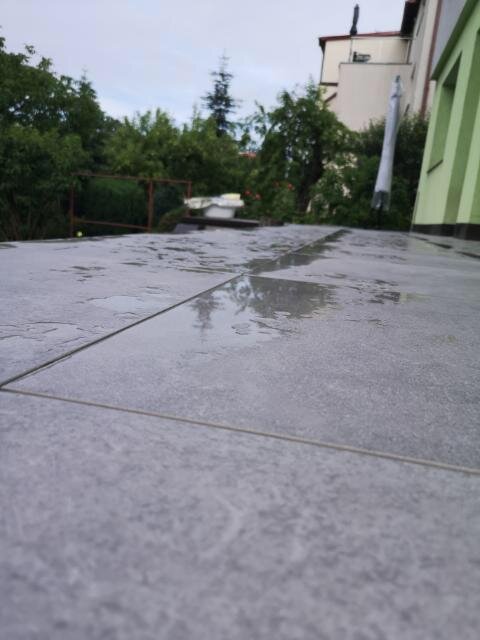 Stauwasser auf den Platten der Terrasse