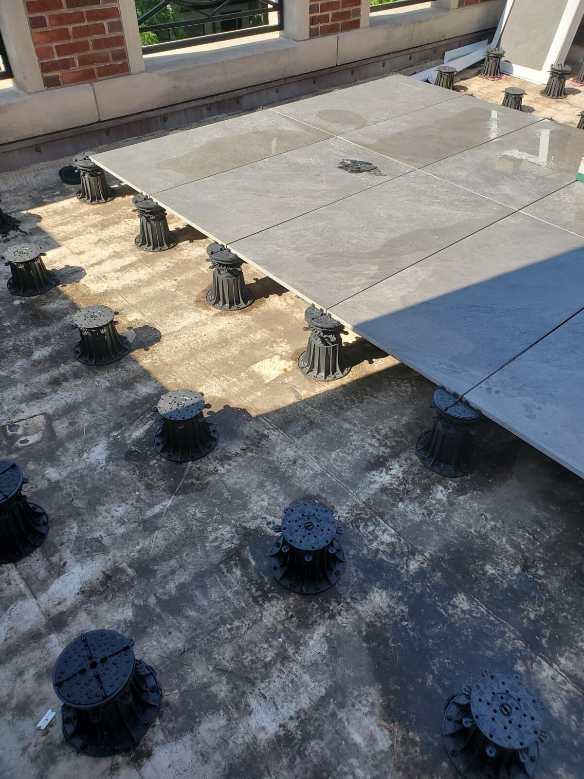 Ein langer Balkon, veredelt mit Terrassendielen aus Holz, mit modernem Geländer.