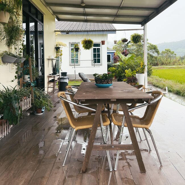 Überdachte Holzterrasse mit stehendem Wasser nach dem Regen.