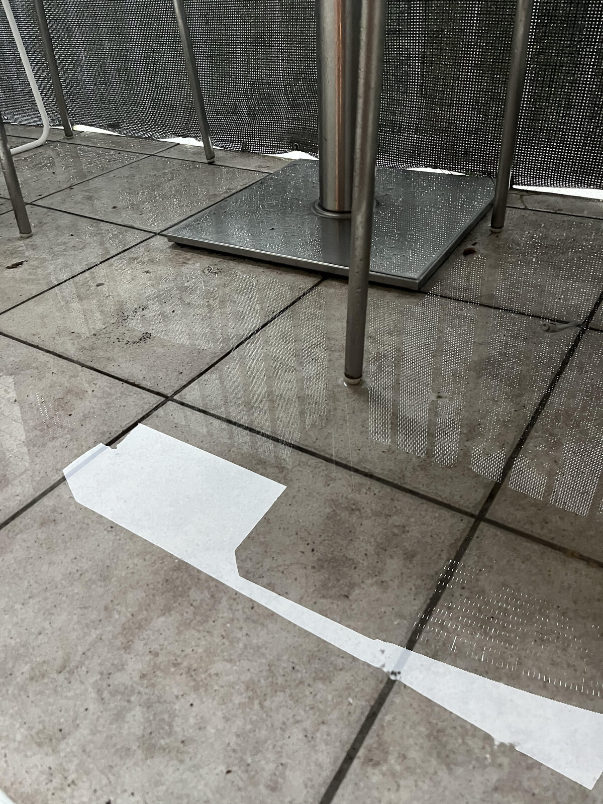 Pfütze und stehendes Wasser auf Balkonplatten unter Möbeln