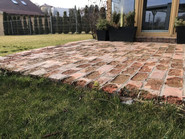 Zerstörte verklebte Terrasse aus Ziegeln auf dem Boden