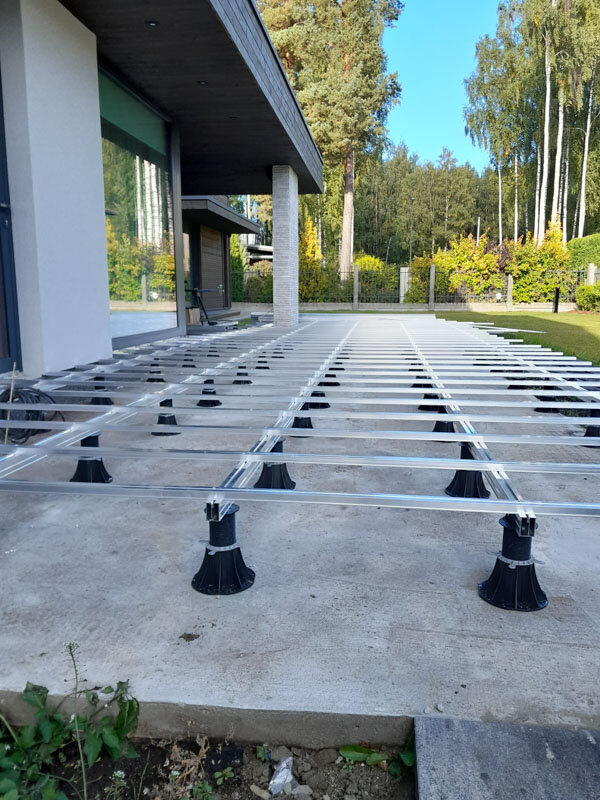 Standard pedestals with joist adapters laid with aluminum joists on a ground-level terrace