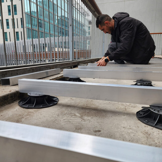 Montage von Aluminium-Balken, unterstützt von höhenverstellbaren Terrassen-Stelzlagern