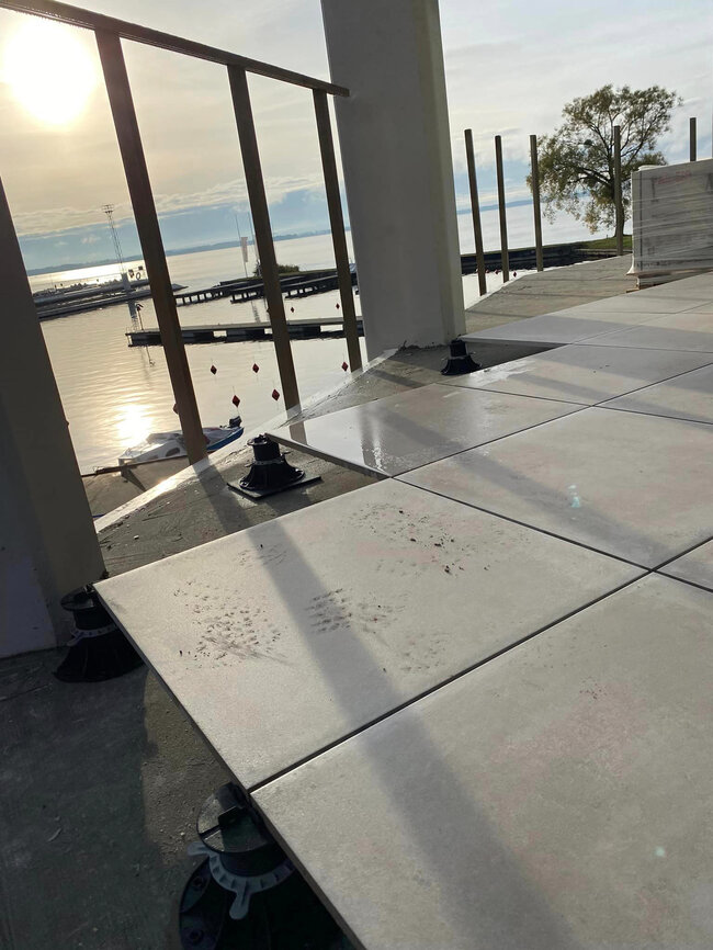 installation of large grey outdoor patio tiles using an adju