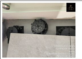 Cut pedestal supports positioning beneath porcelain pavers next to a wall edge.