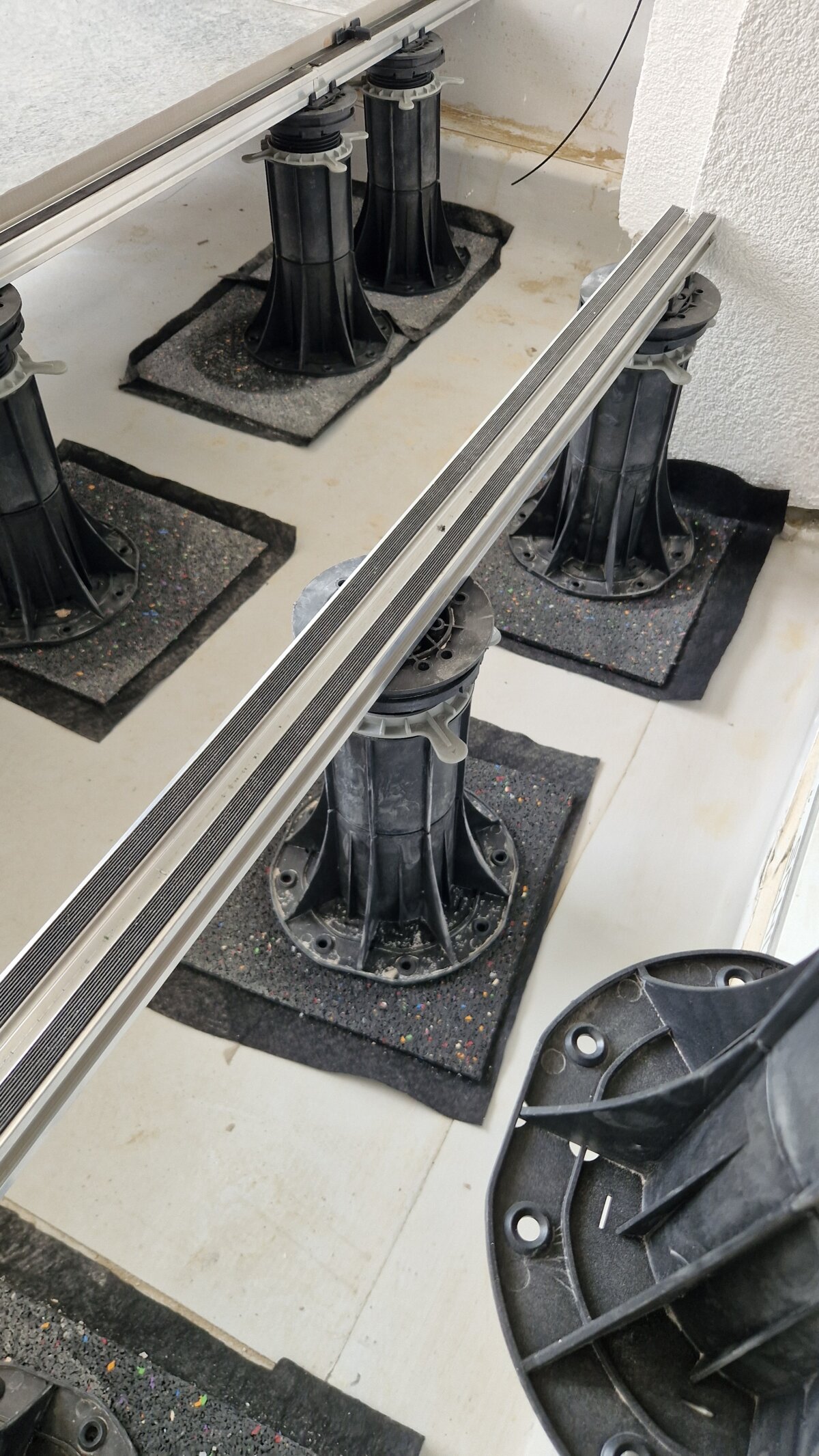 System wsporników regulowanych z legarami aluminiowymi do montażu podniesionego tarasu zewnętrznego.