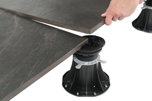 Verlegung dunkler Porzellan-Terrassenplatten auf höhenverstellbaren Kunststoff-Stelzlagern.