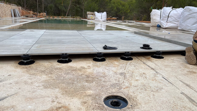 Installation von Terrassenplatten aus Porzellan auf höhenverstellbaren Terrassen Stelzlagern.