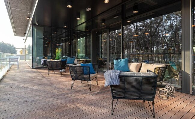 Moderne Lounge-Sitzmöbel, die auf einer sauberen, erhöhten Holzterrasse angeordnet sind.