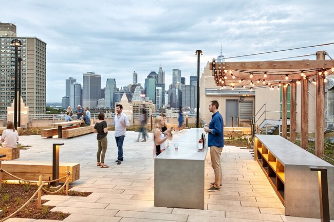 Moderne Dachterrasse mit erhöhten Steinplatten auf höhenverstellbaren Stelzlagern.