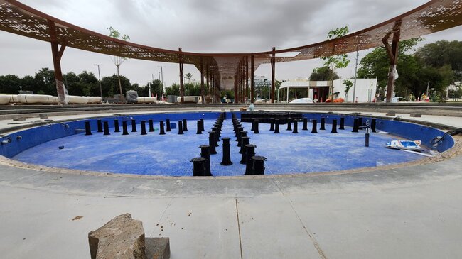 Höhenverstellbare Stelzlager, montiert über einem blau gefliesten Brunnenbecken in einem erhöhten Außenbodensystem einer Wasserinstallation.