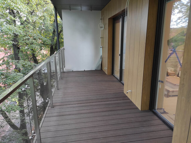 Fertige Verbundstoffterrasse, montiert auf einem modernen Balkon mit höhenverstellbaren Stelzlagern.
