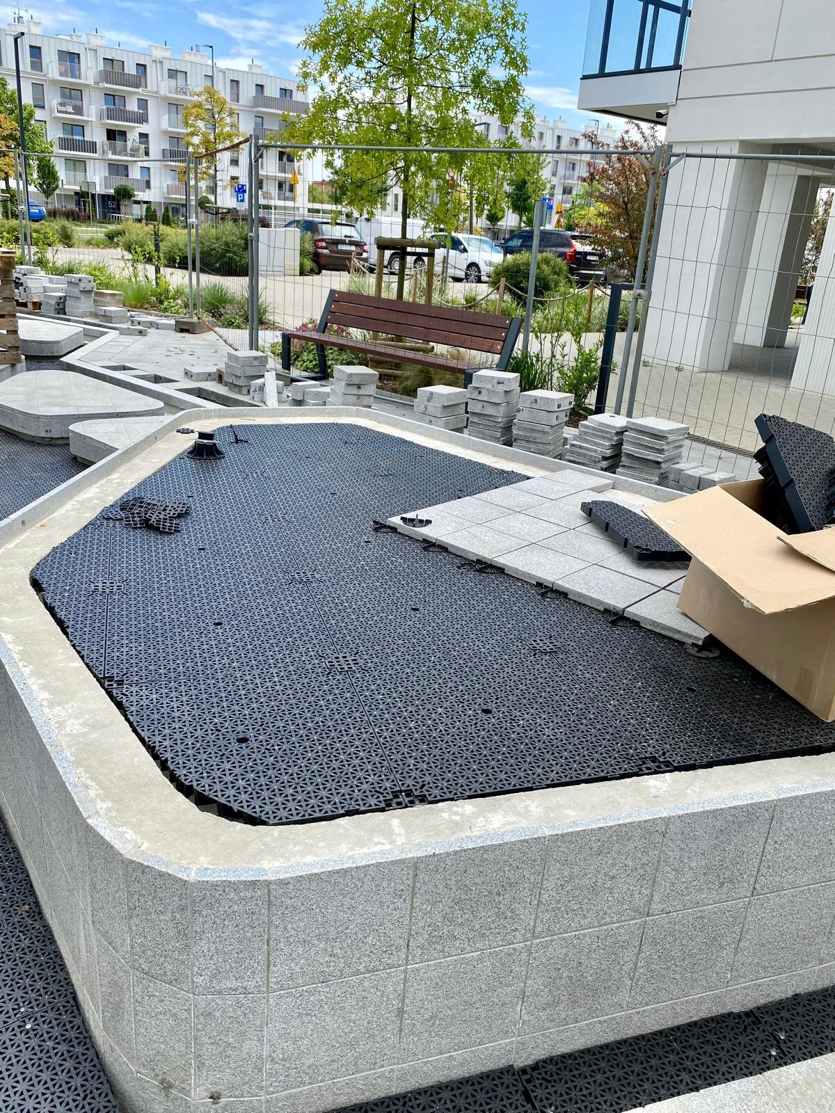 DeckSafe Stelzlager-System, das ineinandergreifende Drainage-Unterbodenplatten und Terrassenplatten trägt.